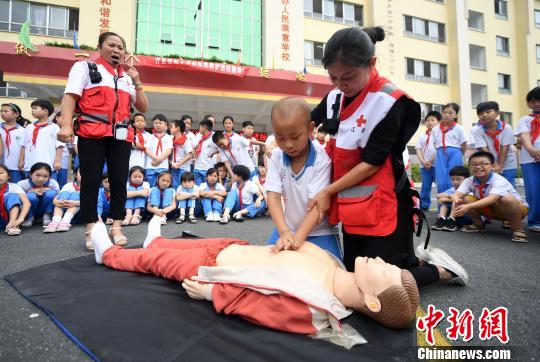 6月13日,一名学生在分宜县红十字应急救护培训讲师的指引下学习心肺复苏术技巧。 周亮 摄