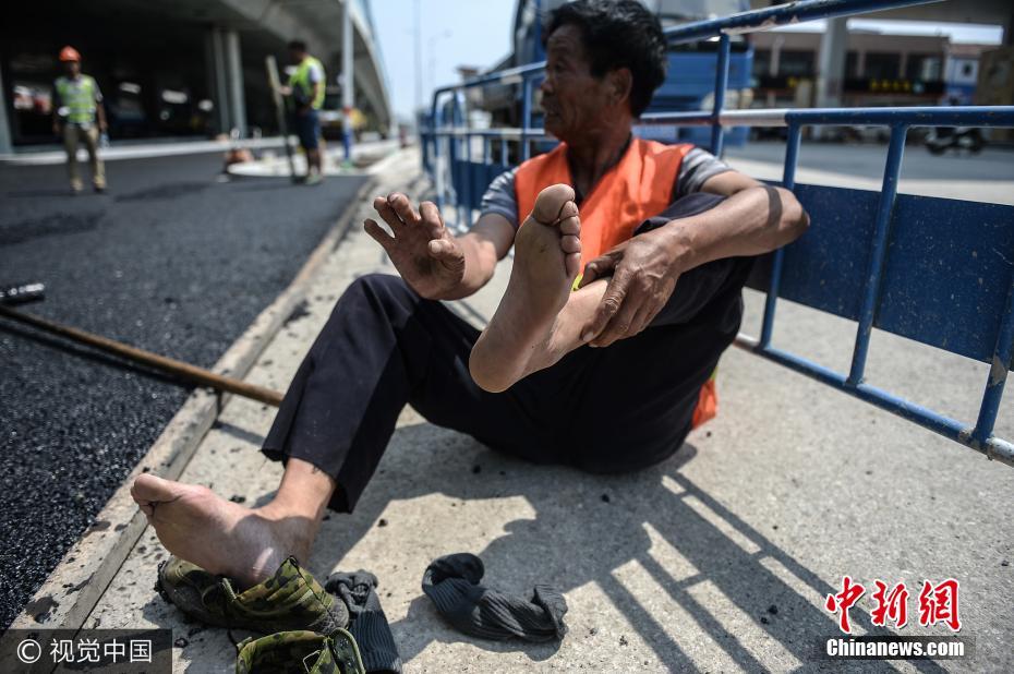 头顶烈日脚踩高温 济南沥青工脚底烫出泡