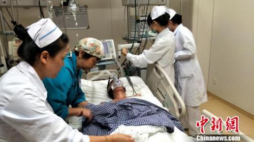 资料图:医护人员为患者插上医疗仪器。徐志雄 摄